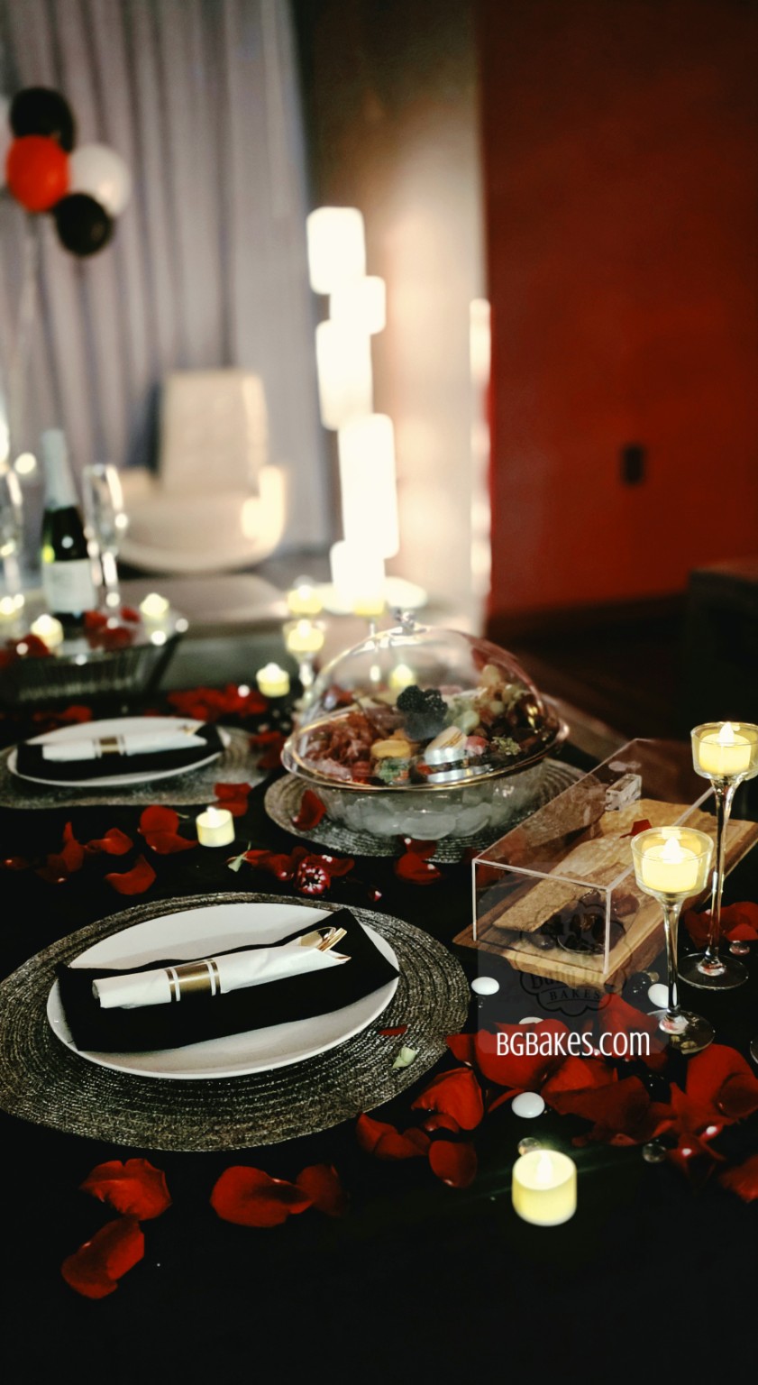 Romantic table styling with charcuterie, rose petals and candlelight